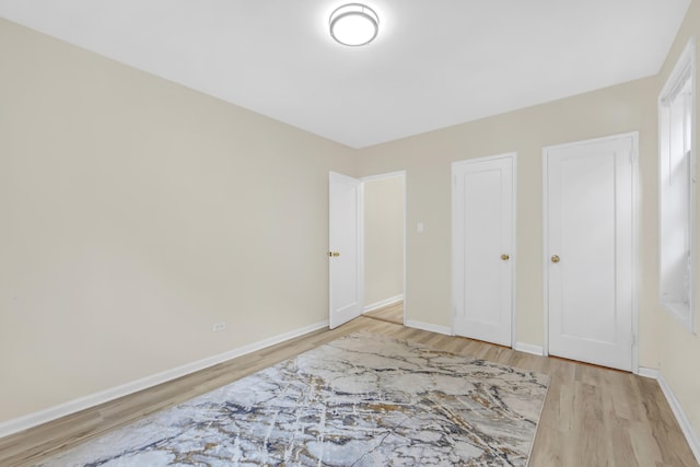 unfurnished bedroom with light wood-style floors and baseboards