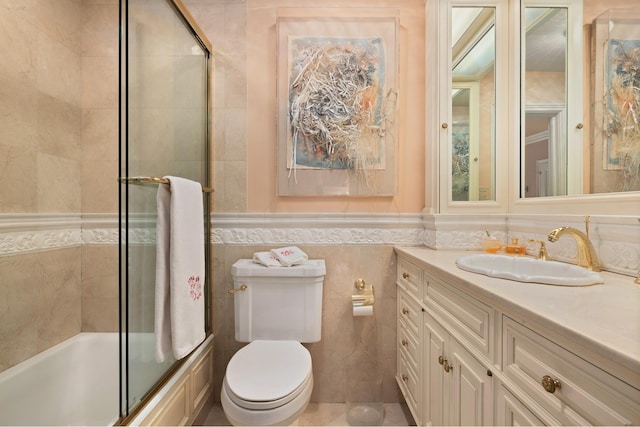 full bath featuring tile walls, shower / bath combination with glass door, toilet, and vanity
