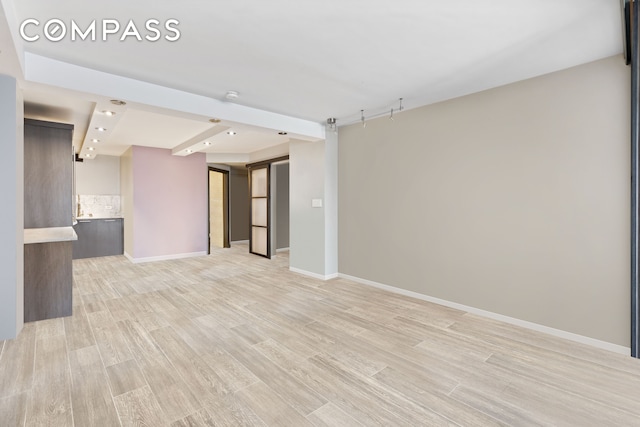 unfurnished living room featuring light wood-style floors and baseboards