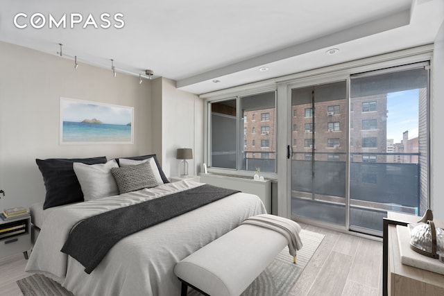 bedroom with access to exterior, light wood-type flooring, rail lighting, and recessed lighting