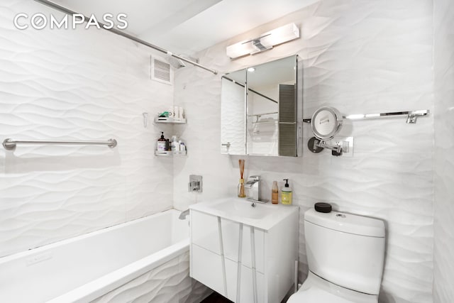 full bathroom with tile walls, toilet, vanity, and bathing tub / shower combination
