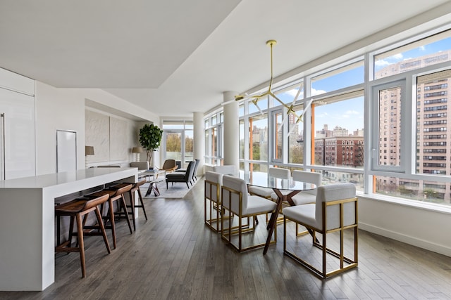 dining room with baseboards, dark wood-style flooring, and a view of city
