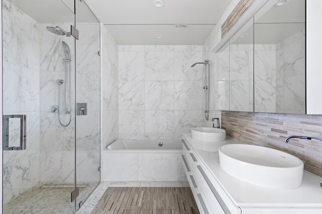 full bathroom featuring tile walls, a marble finish shower, and a sink