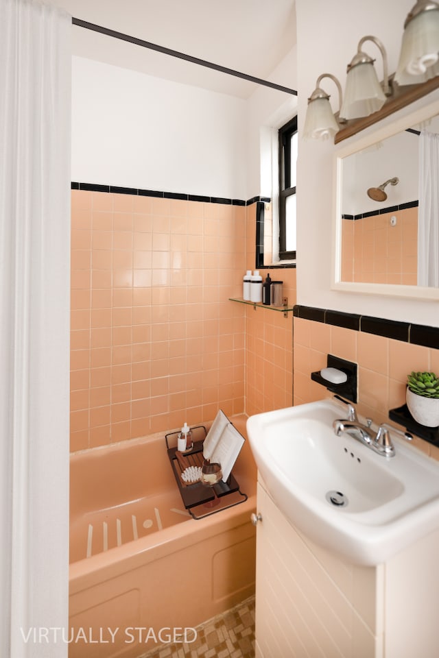 bathroom with tile walls, shower / bath combination with curtain, and vanity