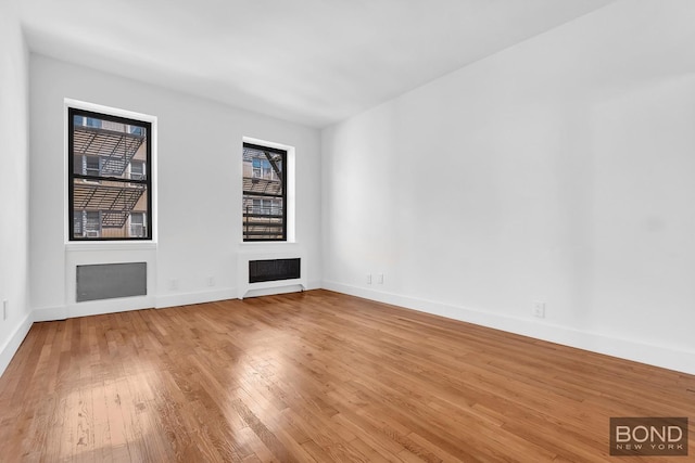 418 E 83rd St Unit 3C, New York City, NY 10028 - empty room with healthy amount of natural light, wood finished floors, baseboards, and a fireplace