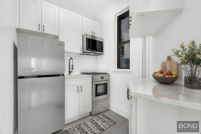 418 E 83rd St Unit 3C, New York City, NY 10028 - kitchen featuring appliances with stainless steel finishes, a sink, backsplash, and light countertops