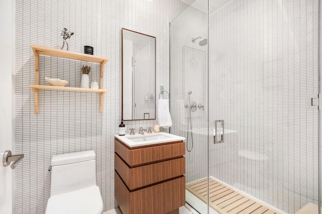 full bath with toilet, tile walls, a shower stall, and vanity