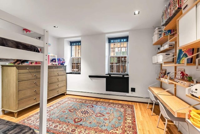 314 E 50th St Unit 1E, New York City, NY 10022 - bedroom featuring baseboard heating and light wood finished floors