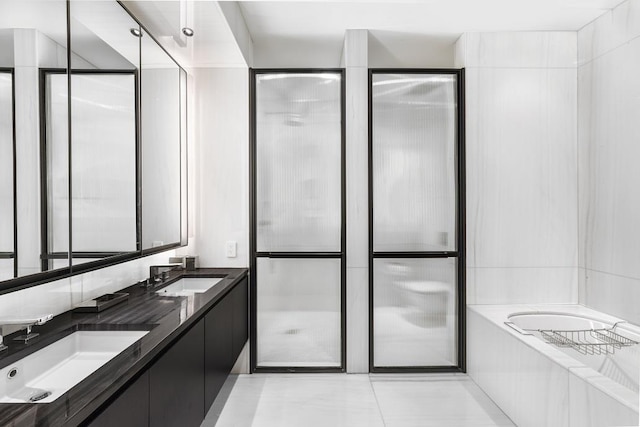 bathroom with a bath, double vanity, and a sink