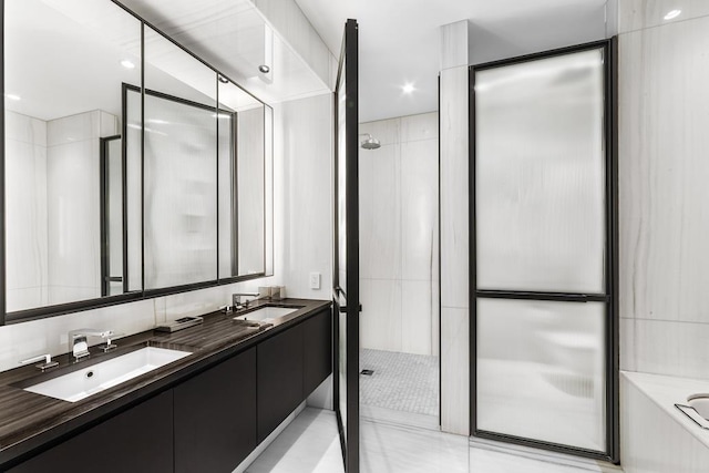 bathroom with a tub, walk in shower, double vanity, and a sink