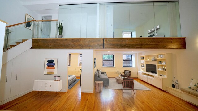 259 21st St Unit 1-C, New York City, NY 11215 - living area with wood finished floors, stairway, a towering ceiling, and baseboards