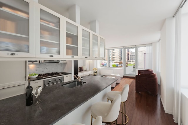 kitchen featuring a sink, stainless steel gas stovetop, dark wood-type flooring, and white cabinets