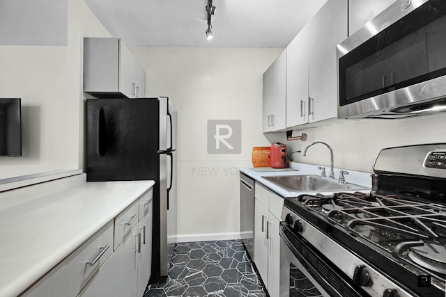 445 W 19th St Unit 3-G, New York City, NY 10011 - kitchen with stainless steel appliances, a sink, light countertops, rail lighting, and baseboards