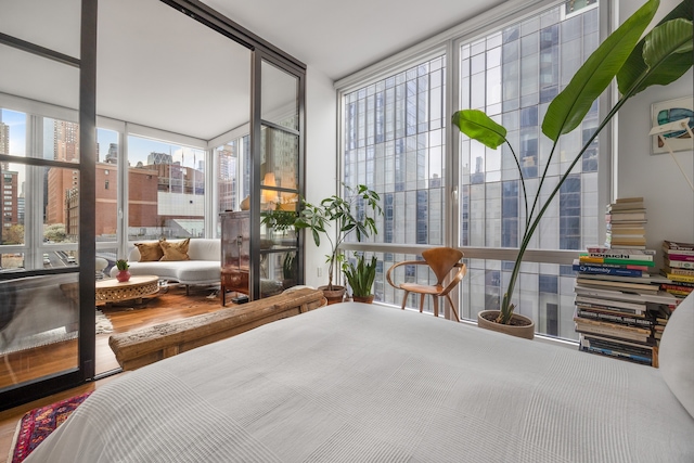 bedroom with a wall of windows and a view of city