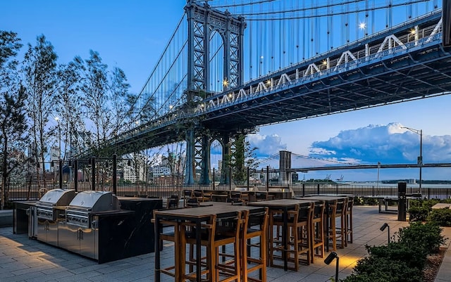 exterior space featuring an outdoor kitchen, fence, and grilling area