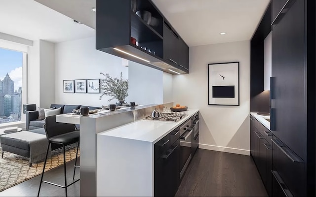 kitchen with light countertops, modern cabinets, dark wood-style flooring, and a peninsula