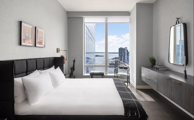 bedroom featuring baseboards, dark wood finished floors, and expansive windows
