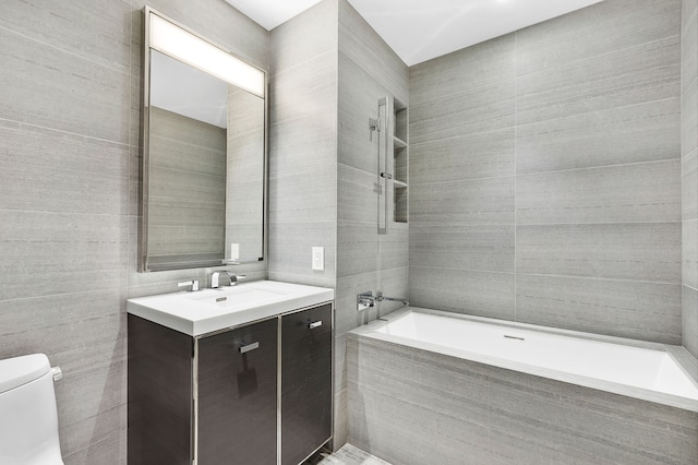 bathroom with tile walls, vanity, and toilet