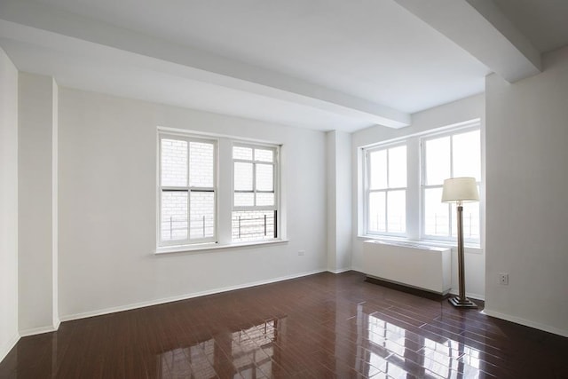 unfurnished room with beam ceiling, baseboards, and dark wood-style floors