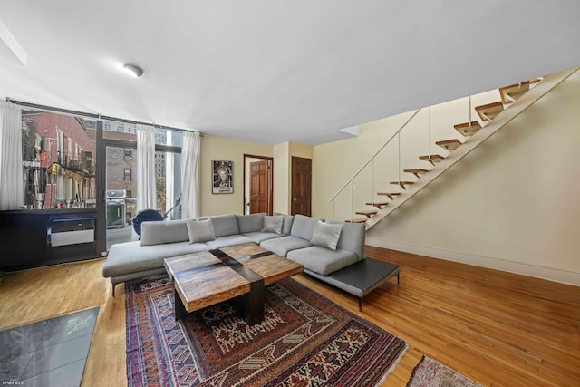 489 W End Ave, New York City, NY 10024 - living area with baseboards, a wall of windows, wood finished floors, and stairway