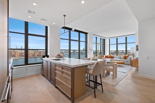 180 Front St Unit 17-E, New York City, NY 11201 - kitchen with a breakfast bar, light countertops, an island with sink, open floor plan, and a water view