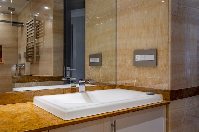 58 W 58th St Unit 30-E, New York City, NY 10019 - bathroom with vanity, a shower, and a towel warming rack