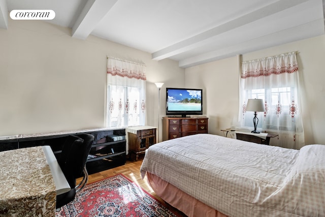 bedroom featuring beam ceiling, multiple windows, and visible vents