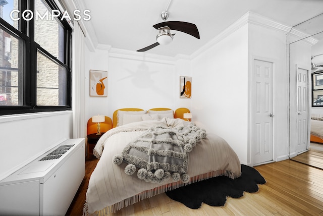 bedroom with ornamental molding, wood finished floors, and ceiling fan