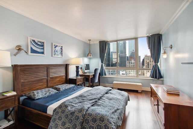 bedroom with wood finished floors, crown molding, and baseboards