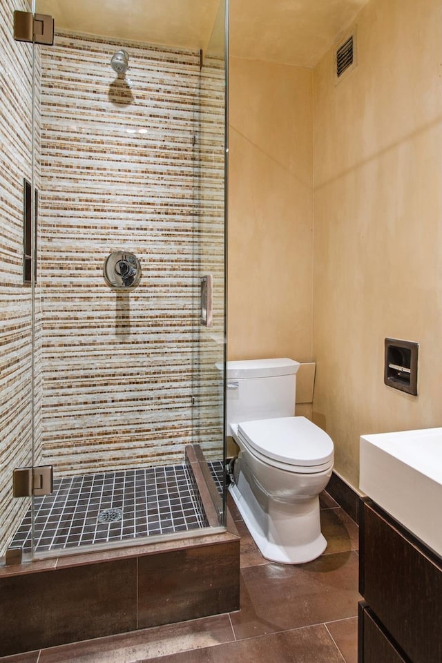 bathroom featuring a shower stall, visible vents, toilet, vanity, and tile patterned flooring