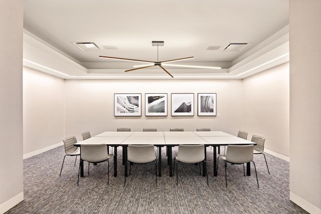 dining area featuring baseboards, visible vents, and a raised ceiling
