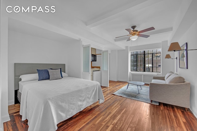 45 Tudor City Pl Unit 1608, New York City, NY 10017 - bedroom featuring radiator heating unit, wood finished floors, baseboards, and a ceiling fan