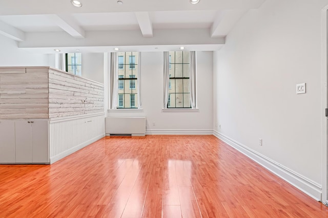 45-02 Ditmars Blvd Unit 231, New York City, NY 11105 - spare room with beamed ceiling, wood finished floors, recessed lighting, a wainscoted wall, and radiator