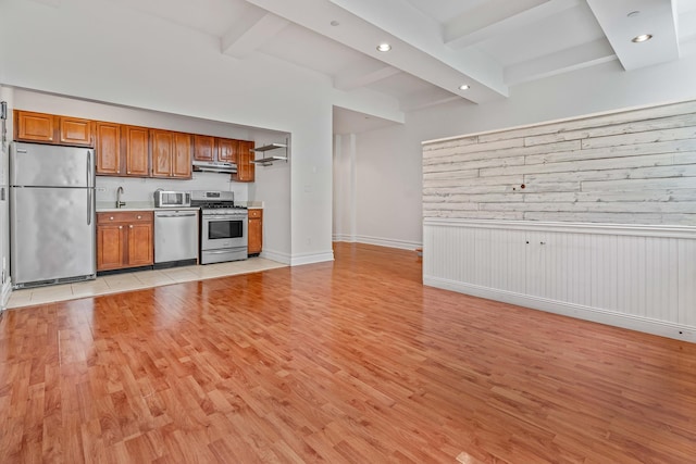 45-02 Ditmars Blvd Unit 231, New York City, NY 11105 - kitchen featuring appliances with stainless steel finishes, under cabinet range hood, beam ceiling, light wood-type flooring, and recessed lighting