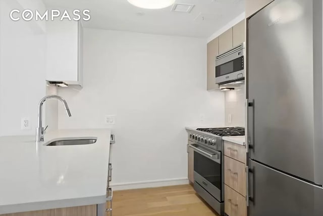171 W 131st St Unit Ph4, New York City, NY 10027 - kitchen with appliances with stainless steel finishes, a sink, light wood-style flooring, light countertops, and modern cabinets