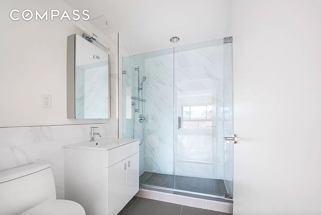 171 W 131st St Unit Ph4, New York City, NY 10027 - bathroom featuring toilet, vanity, a marble finish shower, and tile walls