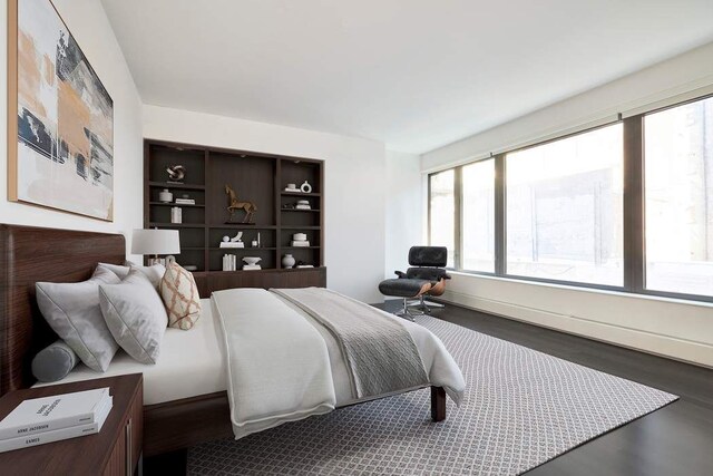 bedroom with dark wood-style flooring, visible vents, baseboards, a closet, and a baseboard heating unit