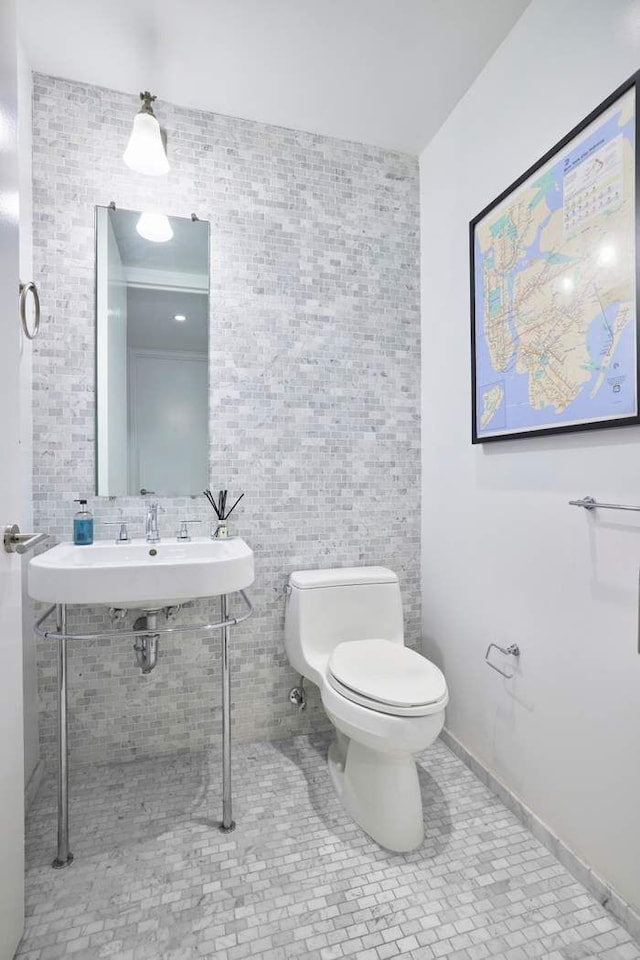 505 Greenwich St Unit 3D, New York City, NY 10013 - bathroom featuring toilet, tile walls, and tile patterned floors
