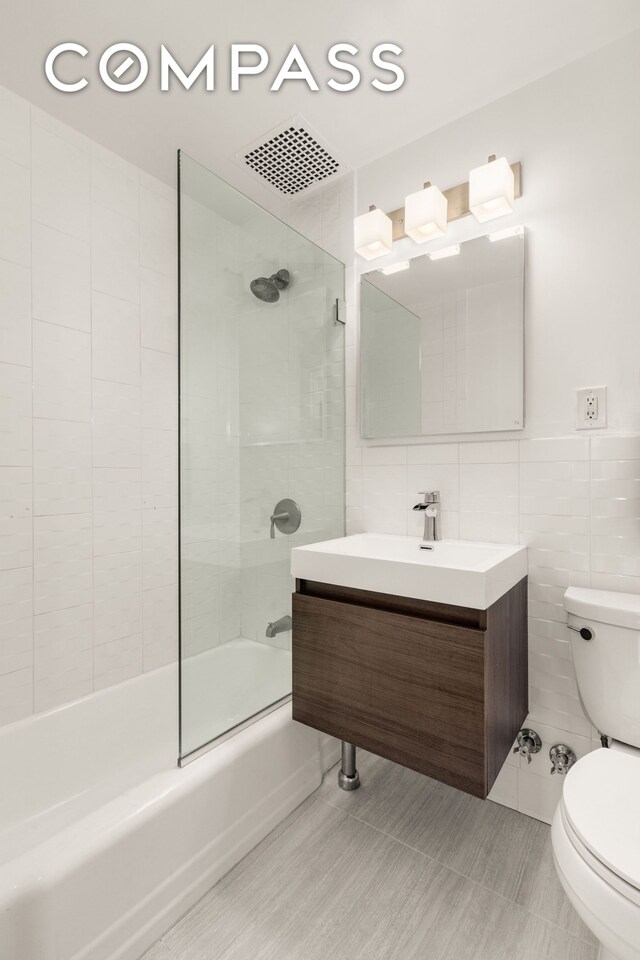 111 E 36th St Unit 4A, New York City, NY 10016 - bathroom with tile walls, toilet, washtub / shower combination, and vanity