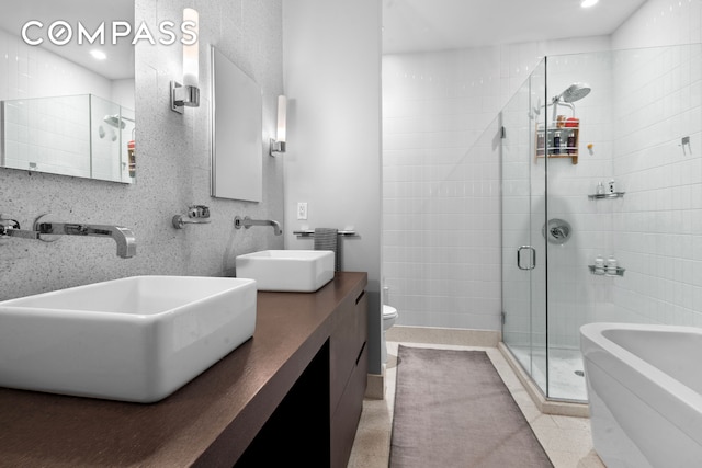 bathroom featuring a sink, a stall shower, toilet, recessed lighting, and a bathtub