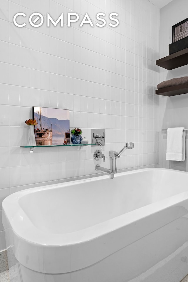 bathroom featuring tile walls and a bathtub