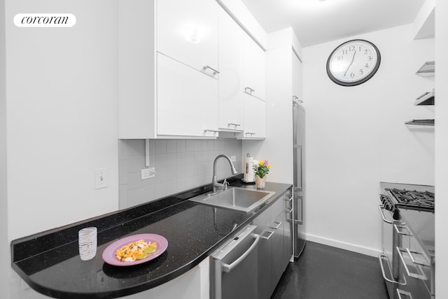 210 E 15th St Unit 1A, New York City, NY 10003 - kitchen with a sink, appliances with stainless steel finishes, white cabinetry, backsplash, and baseboards