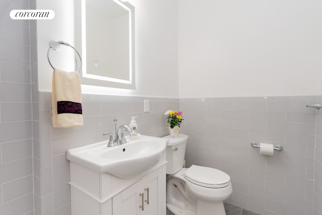 210 E 15th St Unit 1A, New York City, NY 10003 - bathroom with vanity, toilet, tile walls, and a wainscoted wall