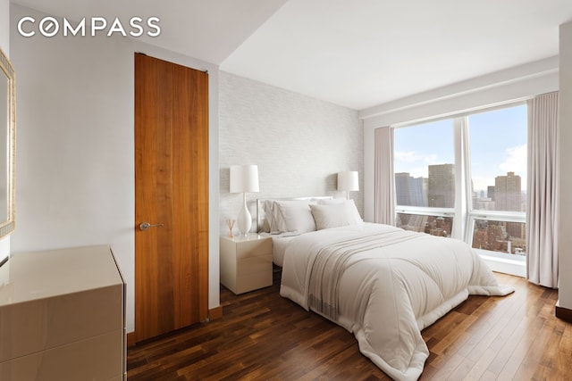400 5th Ave Unit 41D, New York City, NY 10018 - bedroom featuring dark wood-style flooring and a skyline view