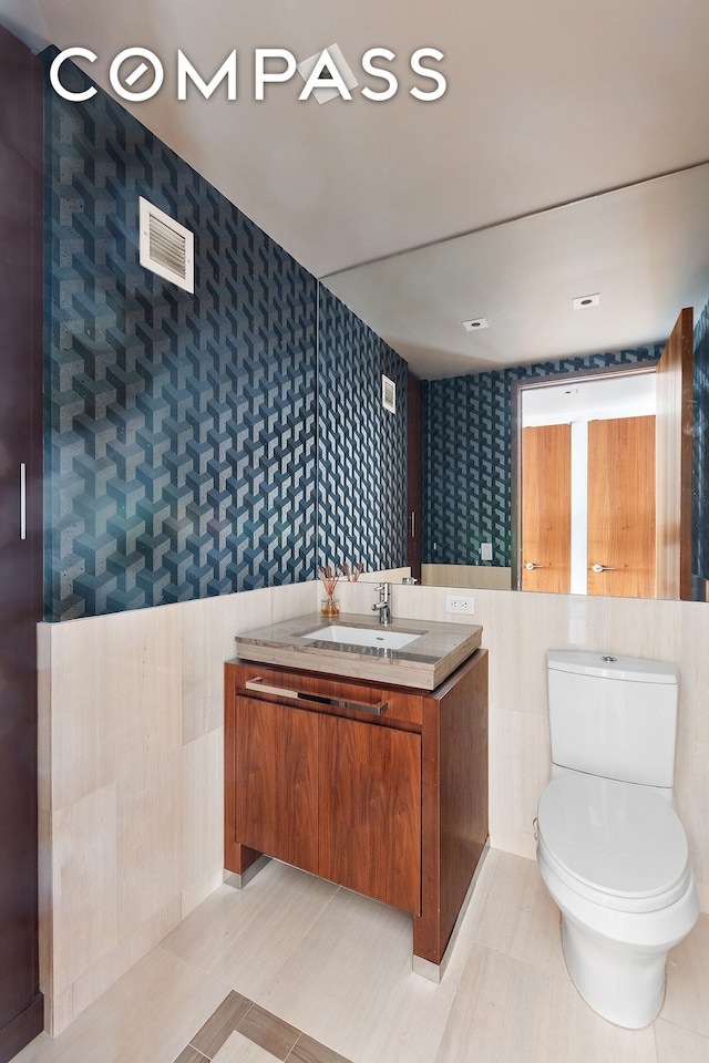 400 5th Ave Unit 41D, New York City, NY 10018 - bathroom with wallpapered walls, vanity, and toilet
