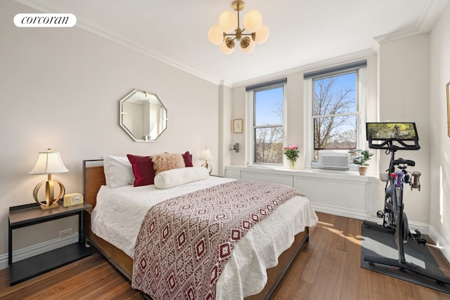 bedroom featuring crown molding, wood finished floors, and a chandelier