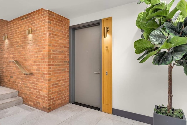 doorway to property with brick siding and stucco siding