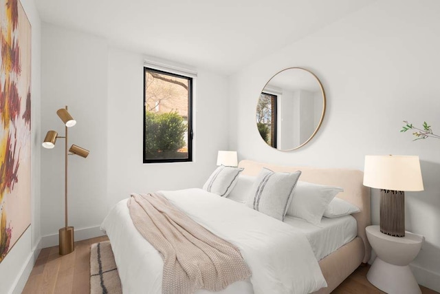 bedroom featuring wood finished floors and baseboards