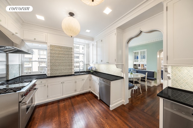 1 E End Ave Unit 8/9B, New York City, NY 10075 - kitchen featuring stainless steel appliances, under cabinet range hood, dark wood-style floors, white cabinetry, and crown molding