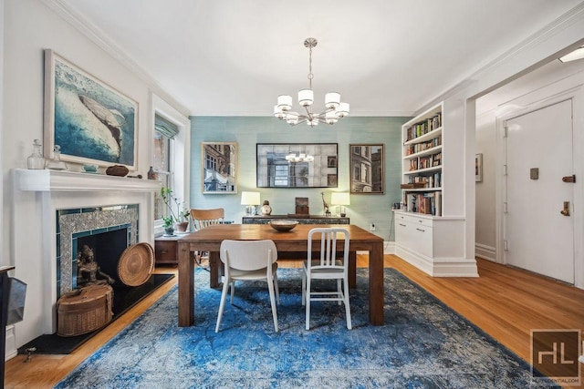 311 W 97th St Unit 3N, New York City, NY 10025 - dining area featuring wood finished floors, a chandelier, a fireplace, ornamental molding, and baseboards